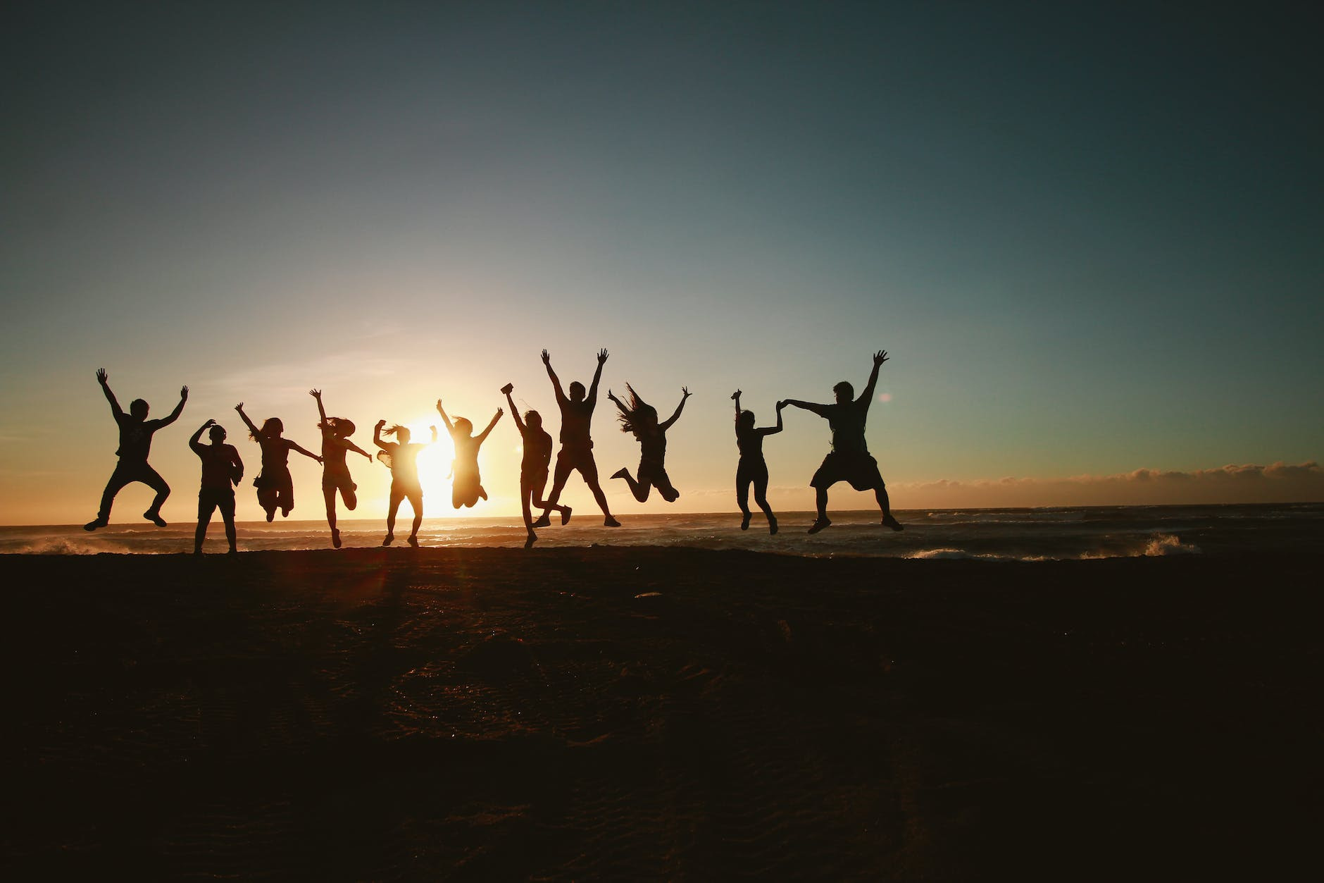 silhouette photography of group of online community jumping during golden time
